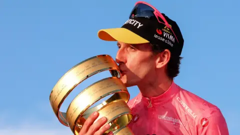 Simon Yates with the Giro d'Italia trophy in 2025