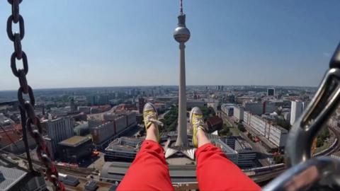 A woman's legs hang over the city
