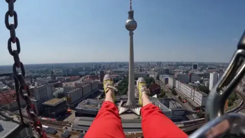 A woman's legs hang over the city