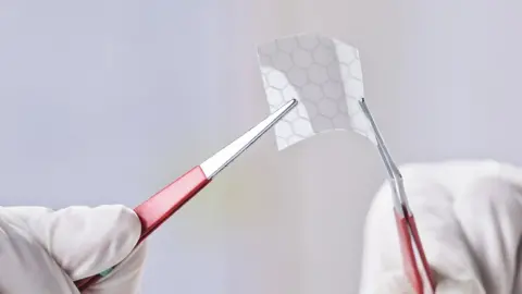 Getty Images Hands holding a piece of graphene