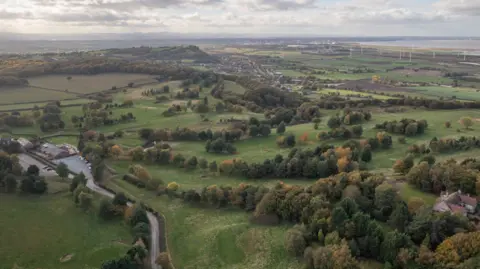 Andy Bond/Woodland Trust Aerial view of hills interspersed with patches of woodland and fields stretching into the distance. 