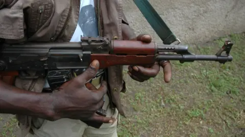 Getty Images A man holds an AK-47 rifle (file image)