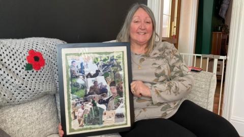 Denise Carter holding photos of her son