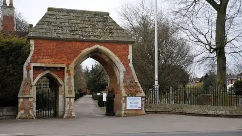 Entrance to Spalding Cemetery a brick archway with pitched roof and iron gates