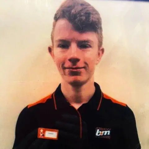 Kevin Page A young man with red hair and a black top with the B&M shop logo