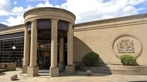 BBC The outside of the High Court in Glasgow. a sandstone building with pillars at the entrance and the legal system insignia on the wall
