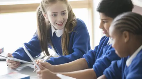 Getty Images Three pupils next to a window at school
