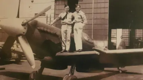 Supplied Derrick's Dad Ernest (left) on the wing of a fighter