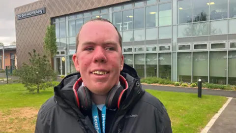 Photograph of Harry Clayton from Marple who has learning difficulties. He gets paid work at the Light Cinema and at the Seashell Trust in Stockport. 