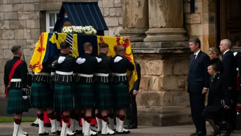 PA Media Princess Anne curtseys as her mother's coffin is brought to Edinburgh