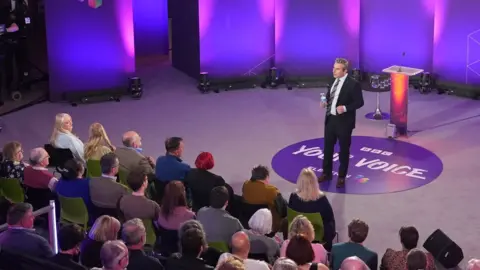 Nick Servini talks to a studio audience