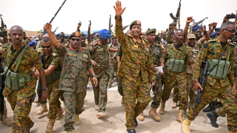 AFP via Getty Images Gen Abdel Fattah al-Burhan (centre) walks with Sudanese government soldiers. File photo