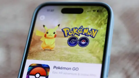 Getty Images Pokemon Go Logo with Pikachu on the phone screen.