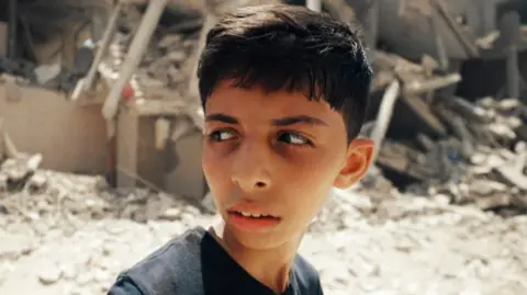 BBC/Amjad Al Fayoumi/Hoyo Films Abdullah Al-Yazouri walking in front of a demolished building