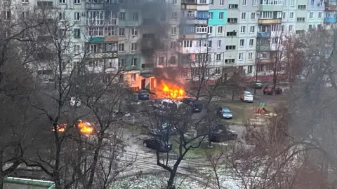 Reuters A fire is seen in Mariupol after Russia launched a massive military operation against Ukraine