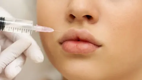 young woman having lip filler