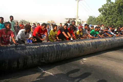 AFP Sudanese erect barricades as they protest against a military coup that overthrew the transition to civilian rule in the al-Shajara district in southern Khartoum, on 25 October 2021