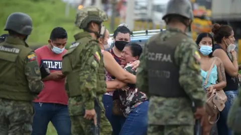 EPA Relatives of inmates await news after the acts of violence experienced inside the Guayaquil prison, in Guayaquil, Ecuador, 23 February 2021.