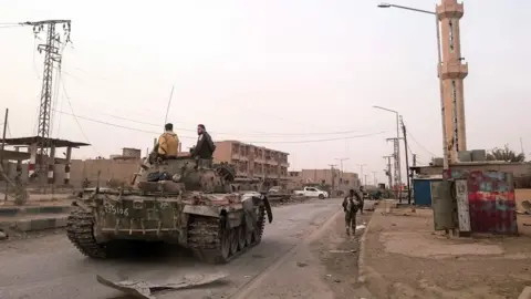 AFP Syrian pro-government forces patrol the eastern border town of Albu Kamal (20 November 2017)