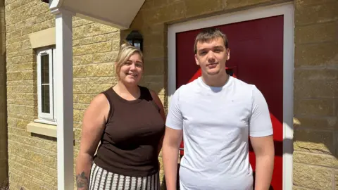 Kayleigh and Jack outside their new home in Martock