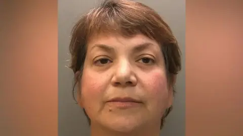 Police custody shot of Zholia Alemi with short brown hair and eyes.