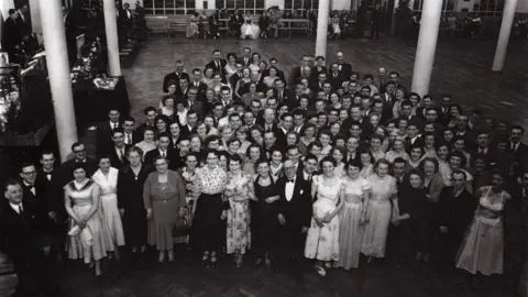 Yate Heritage Centre A large group of people dressed in suits and dresses looking up at the camera while at an event.