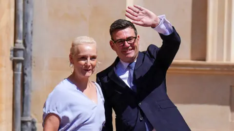 Prime Minister Andy Burnham and his wife Marie-France van Heel, leave Buckingham Palace in London after an audience with King Charles III, where he was invited to become Prime Minister and form a new government.