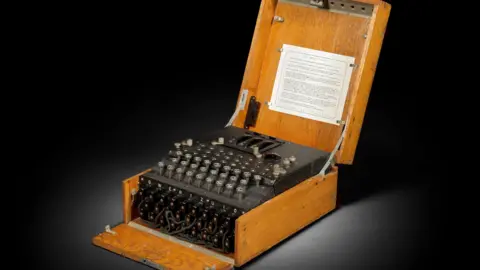 Bonhams A device that looks similar to a typewriter contained in a wooden box.