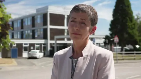 Dr Vanessa Purday looking to the left. She has short hair and is wearing a pink blazer.