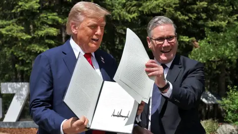 US President Donald Trump (left) holding a UK US trade deal with Prime Minister Sir Keir Starmer while speaking to the media at the G7 summit in Kananaskis, Alberta, Canada. Picture date: Monday June 16, 2025.