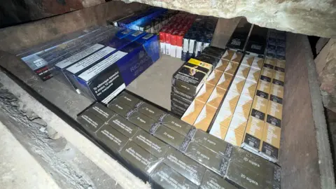 Northumbria Police Packs of cigarettes in a draw in a stone wall.