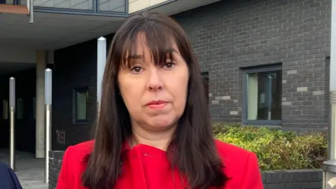 PA Media Roisin Coulter. She has long dark hair with a fringe, brown eyes, wearing a red coat.