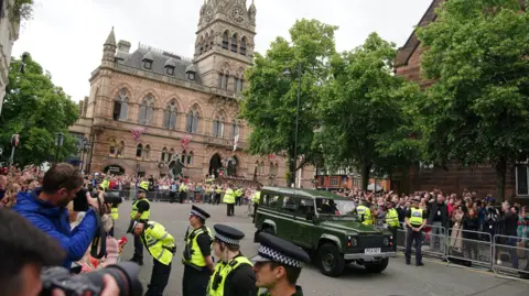 PA Media Photographers and crowds of people watch as a car arrives at the wedding of Hugh Grosvenor, the Duke of Westminster, to Olivia Henson at Chester Cathedral