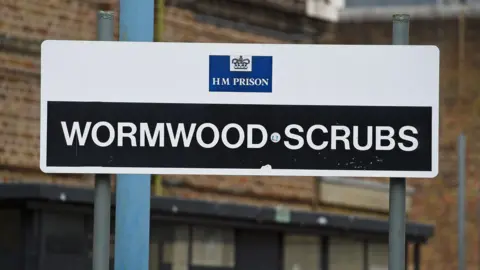 A black and white sign saying HM Prison Wormwood Scrubs