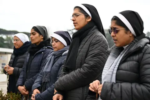 AFP Nuns pray in front of the statue of Pope John Paul II outside Rome's Gemelli Polyclinic, where Pope Francis has been hospitalized on 24 February 2025.