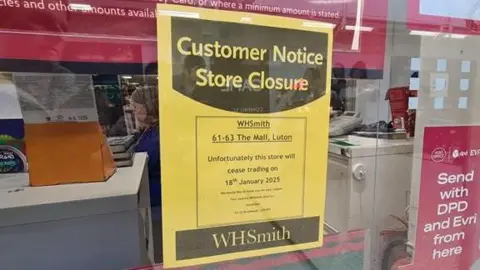 Nicky Schiller/BBC A yellow A4 piece of paper is stuck to the window of WHSmith, warning customers that the store will close on 18 January.