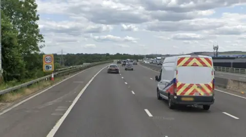 A motorway with a van and cars on the road and a sign alongside it saying 50 with a speed camera symbol