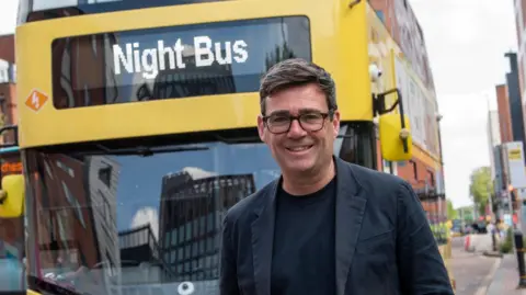 Andy Burnham in front of a Bee Network bus