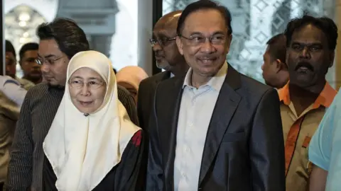 AFP File photo: Anwar Ibrahim (C) and his wife Wan Azizah in 2014