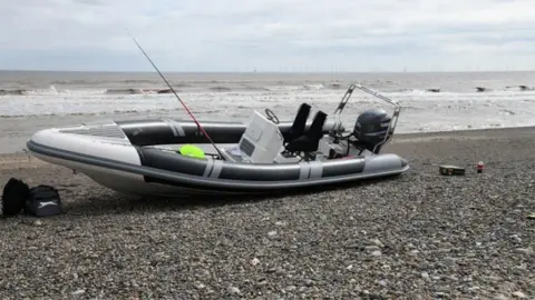 National Crime Agency A police photograph of the grey inflatable boat on the shore at Easington