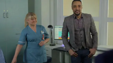 Maria dressed as Nurse Tash onscreen with actor Ashley Rice in a scene from Doctors 