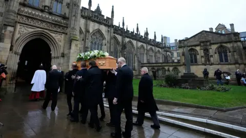 PA Media The coffin of Denis Law is carried into Manchester Cathedral.