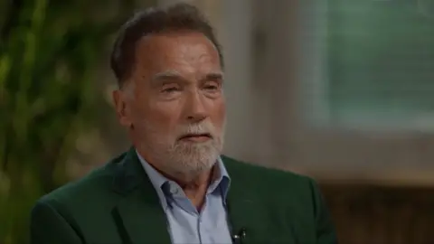 Arnold Schwarzenegger dressed in a shirt and a jacket 