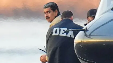 Nicolas Maduro looks over his shoulder