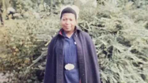 Supplied The picture shows Louise standing in a navy nurses uniform and cape, she is wearing a white nurses hat with her hair tied back. 