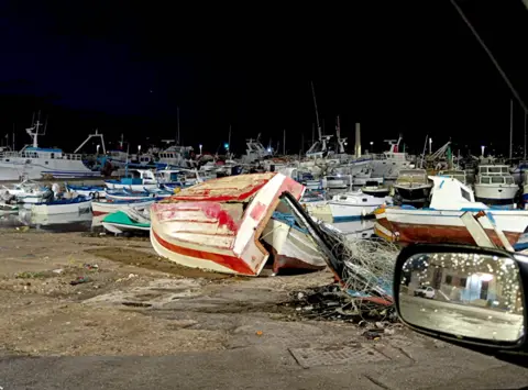 Fabio La Bianca Una piccola barca si è ribaltata e le canne da pesca erano sparse in un porto pieno di barche.