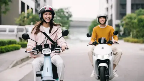 Gogoro Two young people in Taiwan riding scooter motorbikes