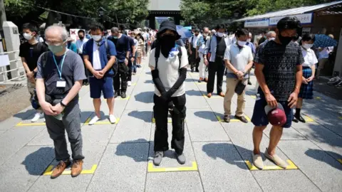 Reuters People practice social distancing while paying a silent tribute during their visit to Yasukuni Shrine