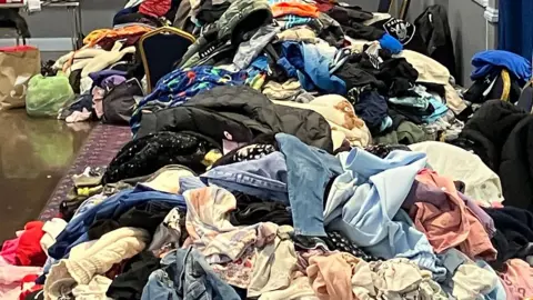 Piles of clothes donations on a table