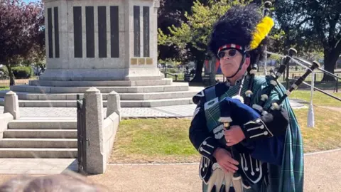A person playing the bagpipes at a VE Day service in Great Yarmouth.